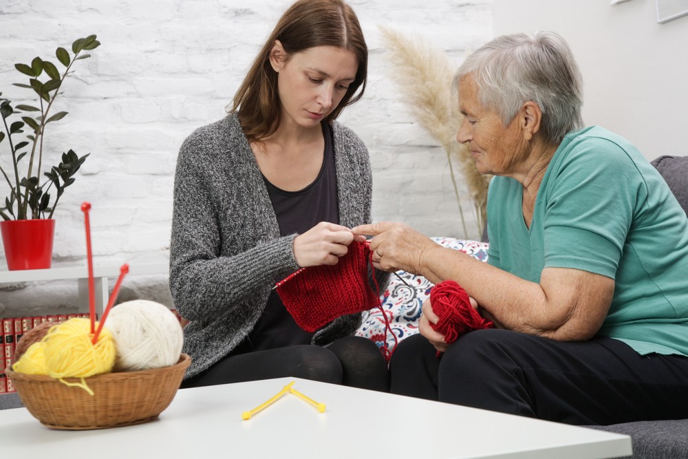 Senior woman knitting with her granddaughter