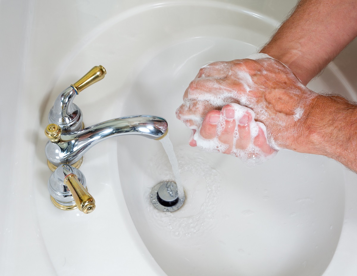 person washing their hands in a sink with soap and water