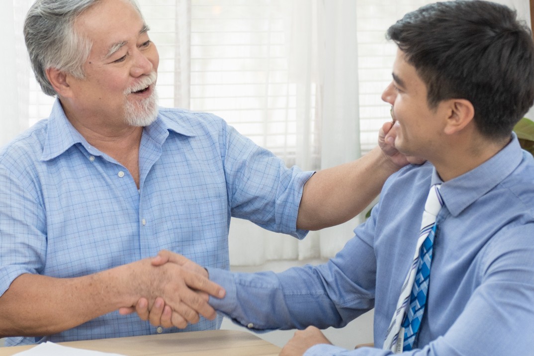 Elder man shaking hands with financial advisor about retirement savings