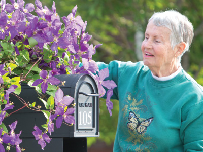 Elderly woman smelling flowers